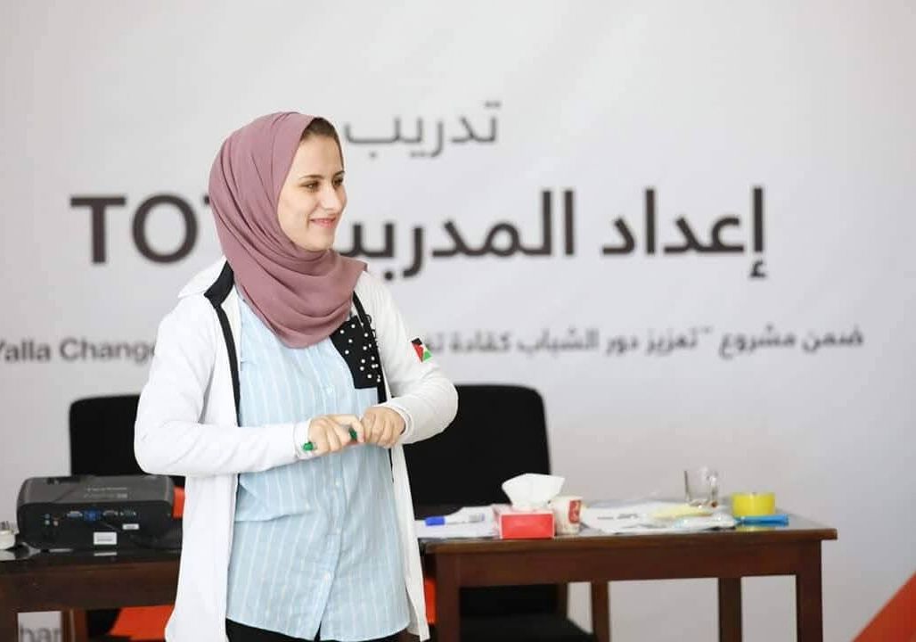 Portrait of Saja Redwan teaching a cohort of students in front of a whiteboard.