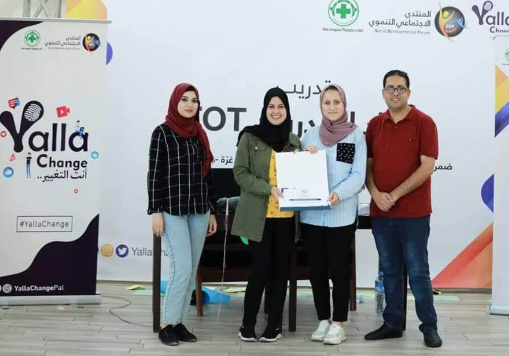 Group photo including Saja Redwan standing in front of a sign that reads 'Yalla Challenge'.